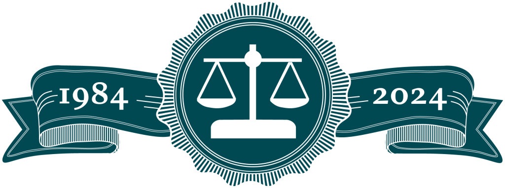 wax stamp outline and detailing with scales of justice stamped in middle circle. Ribbons to side with years 1984 and 2024 written on them.